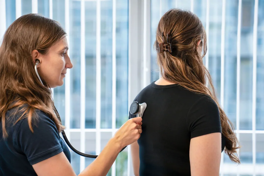 Ärztin hört eine Patientin mit dem Stethoskop ab